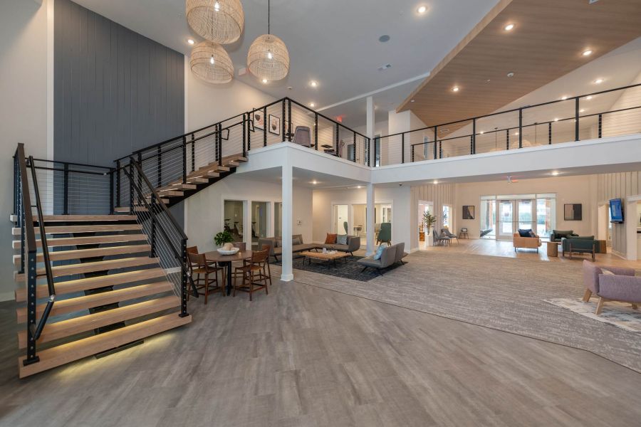 Attain at Chic's Beach homes with Modern, spacious lobby with a staircase, seating areas, and large windows letting in natural light.